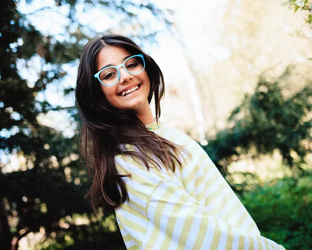 Mädchen mit Brille vor einem Baum