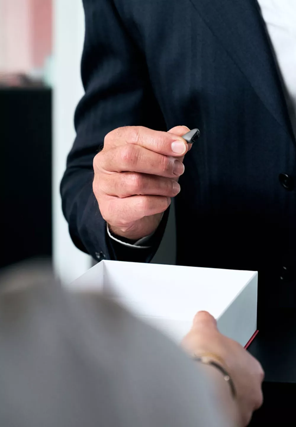 Das TiK® von Hörluchs® auf einer Fingerkuppe – zeigt die winzige Größe